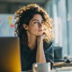Business professional analyzing website analytics and SEO data at a modern, organized office desk with notes and coffee.