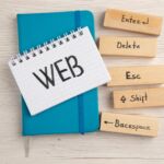 top view web written on small notepad on blue notebook enter delete esc shift backspace icons on